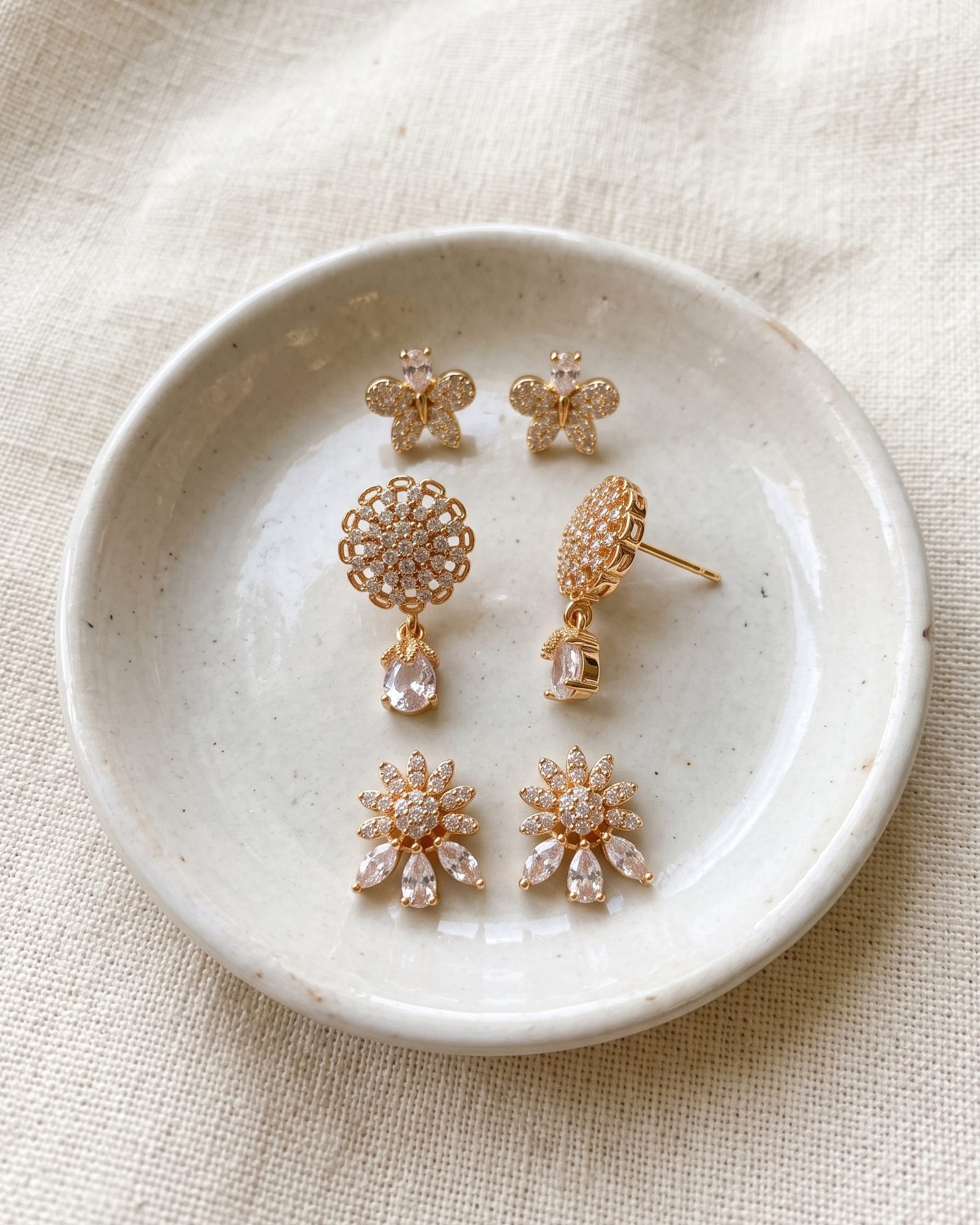 Butterfly Floral AD Stone Earrings Set of 3 laid on white marble