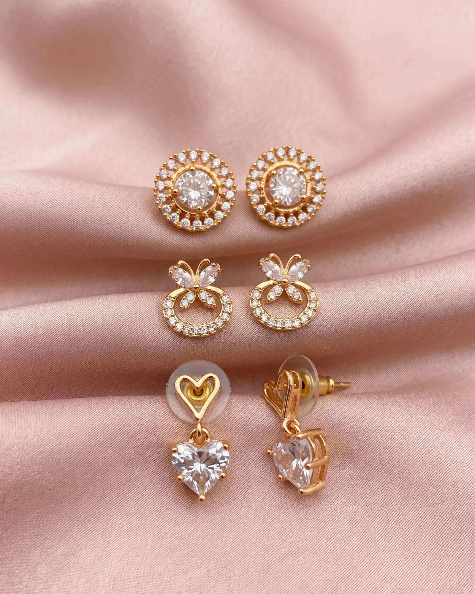 White AD Stone Gold-Tone Earrings Set of 3 laid on white marble