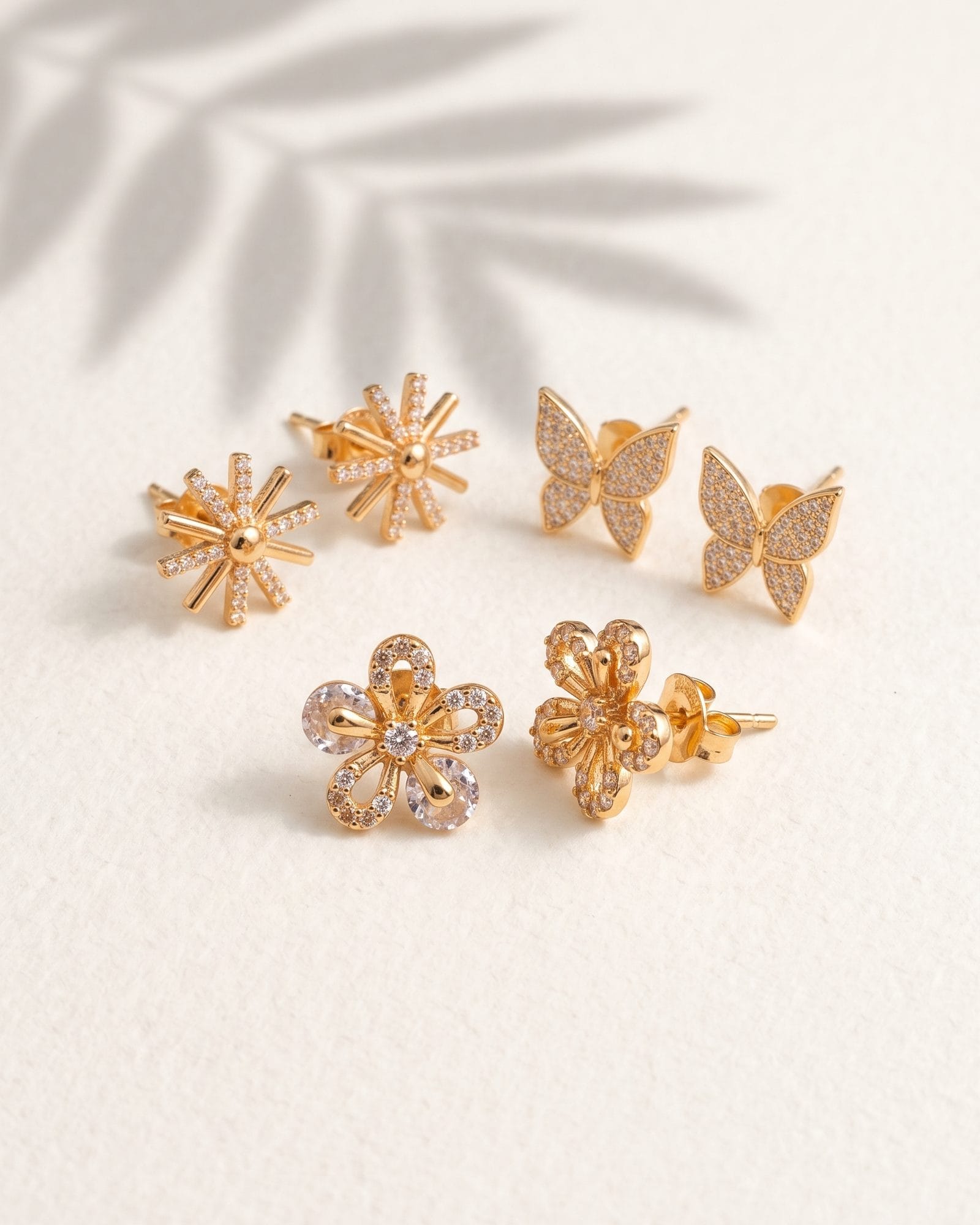 Floral AD Stone Earrings Set of 3 laid on white marble