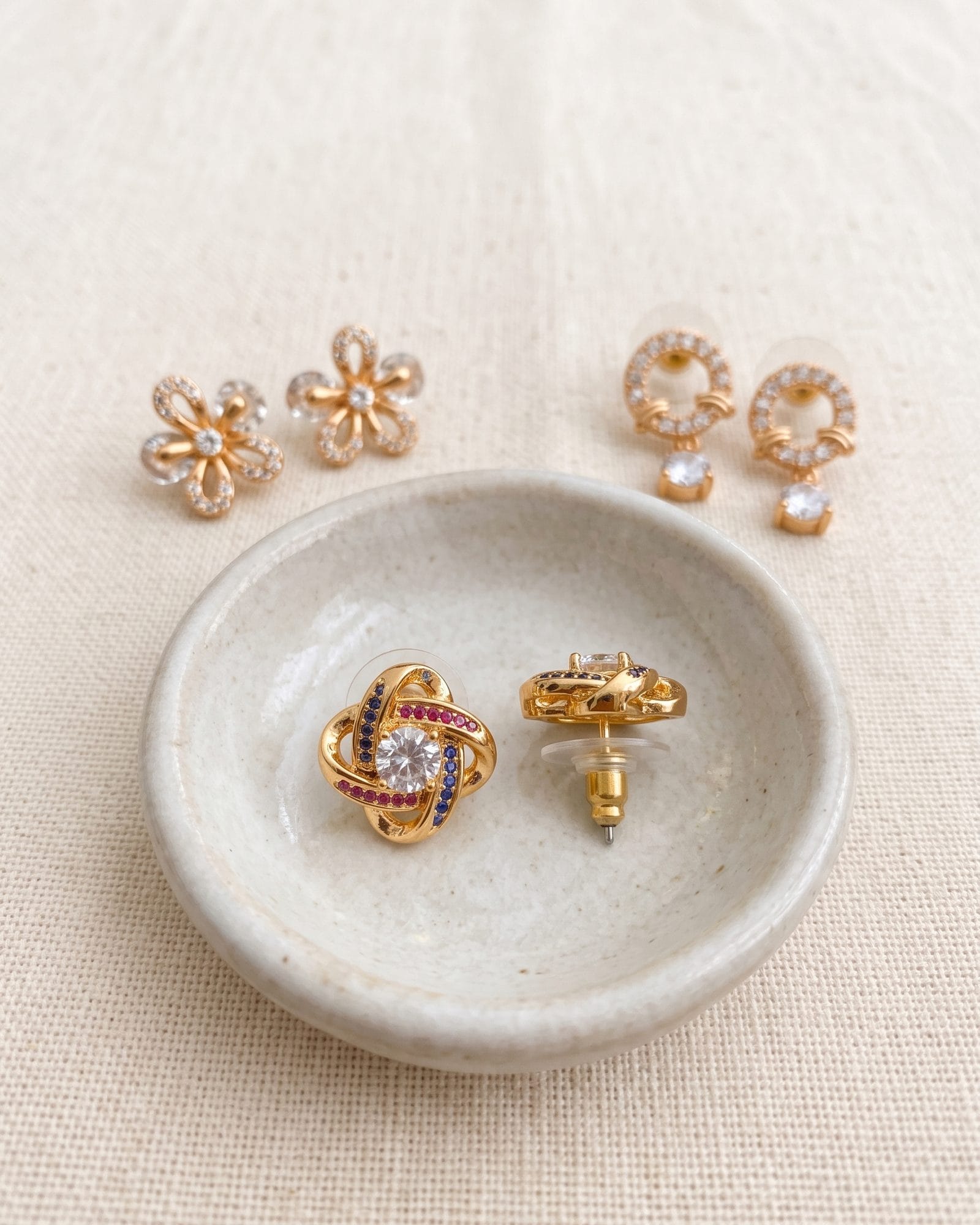 Gold-Tone AD Stone Earrings Set of 3 laid on white marble