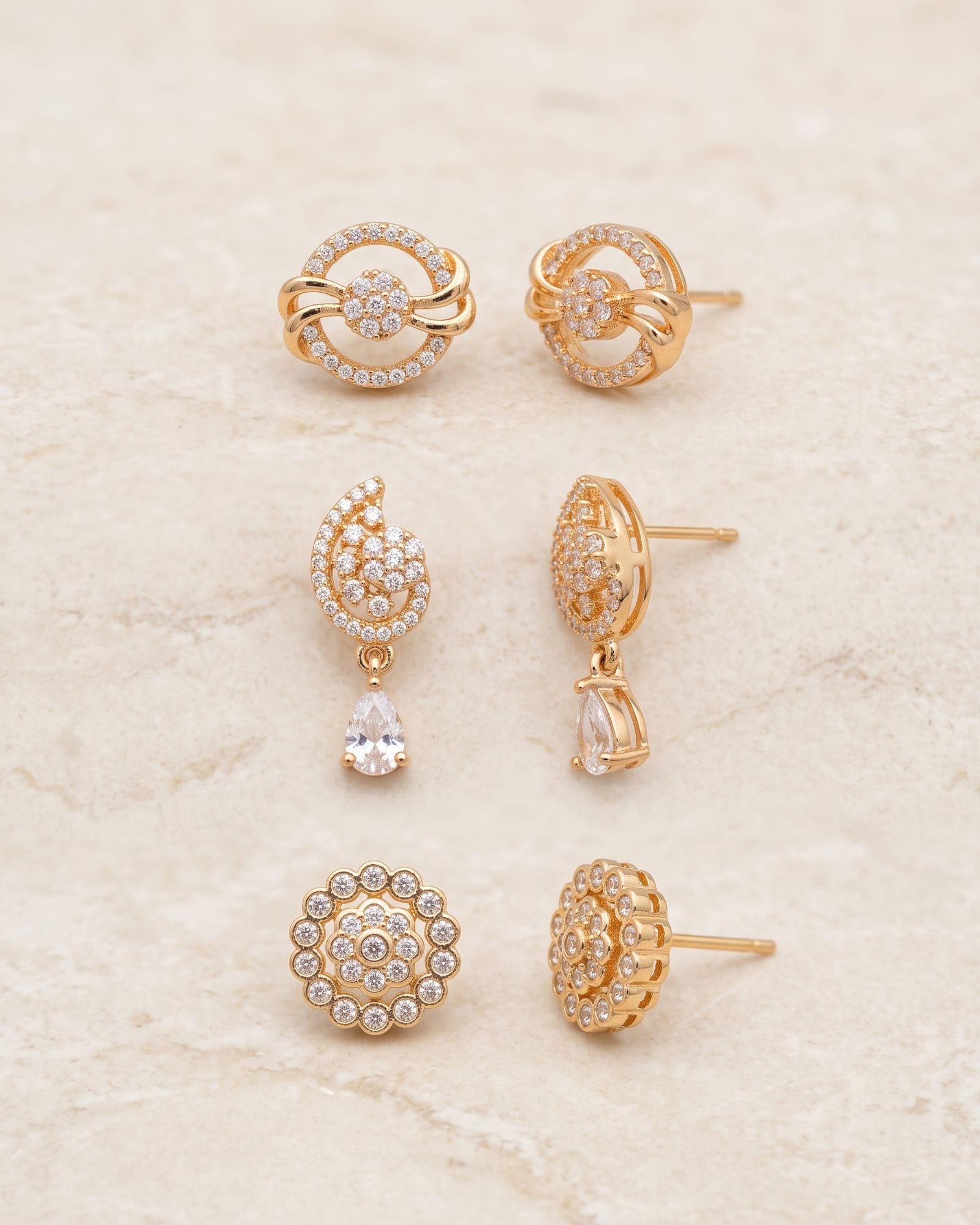 Gold-Tone White AD Stone Earrings Set of 3 laid on white marble