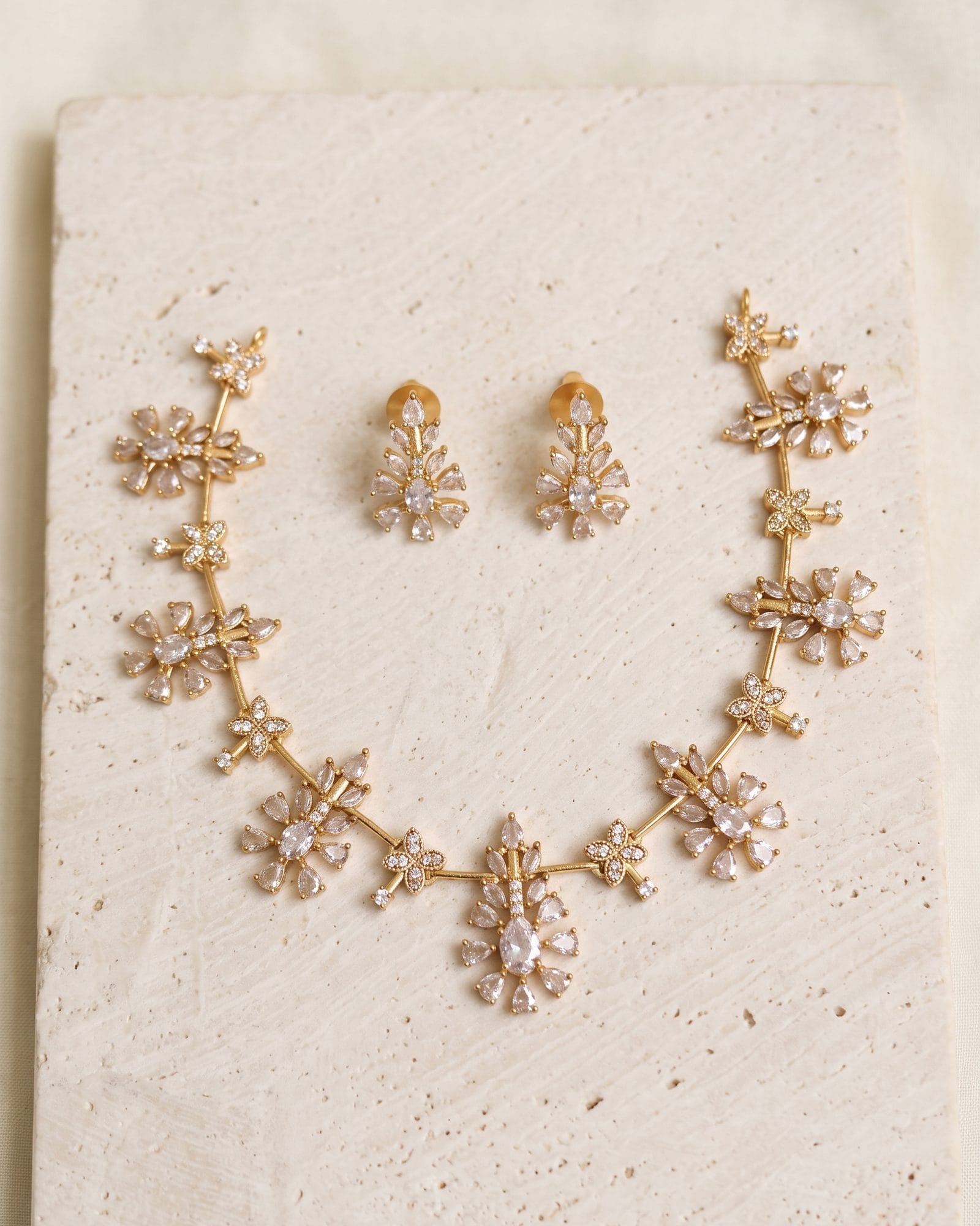 Floral Cluster White AD Stone Necklace laid on white marble