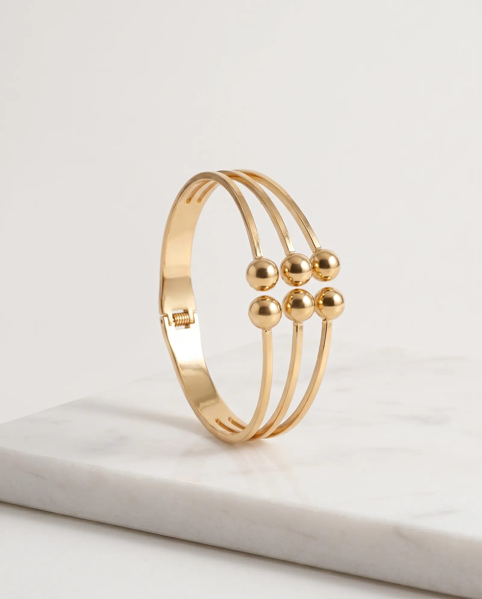 Layered Ball Bangle Anti Tarnish laid on white marble