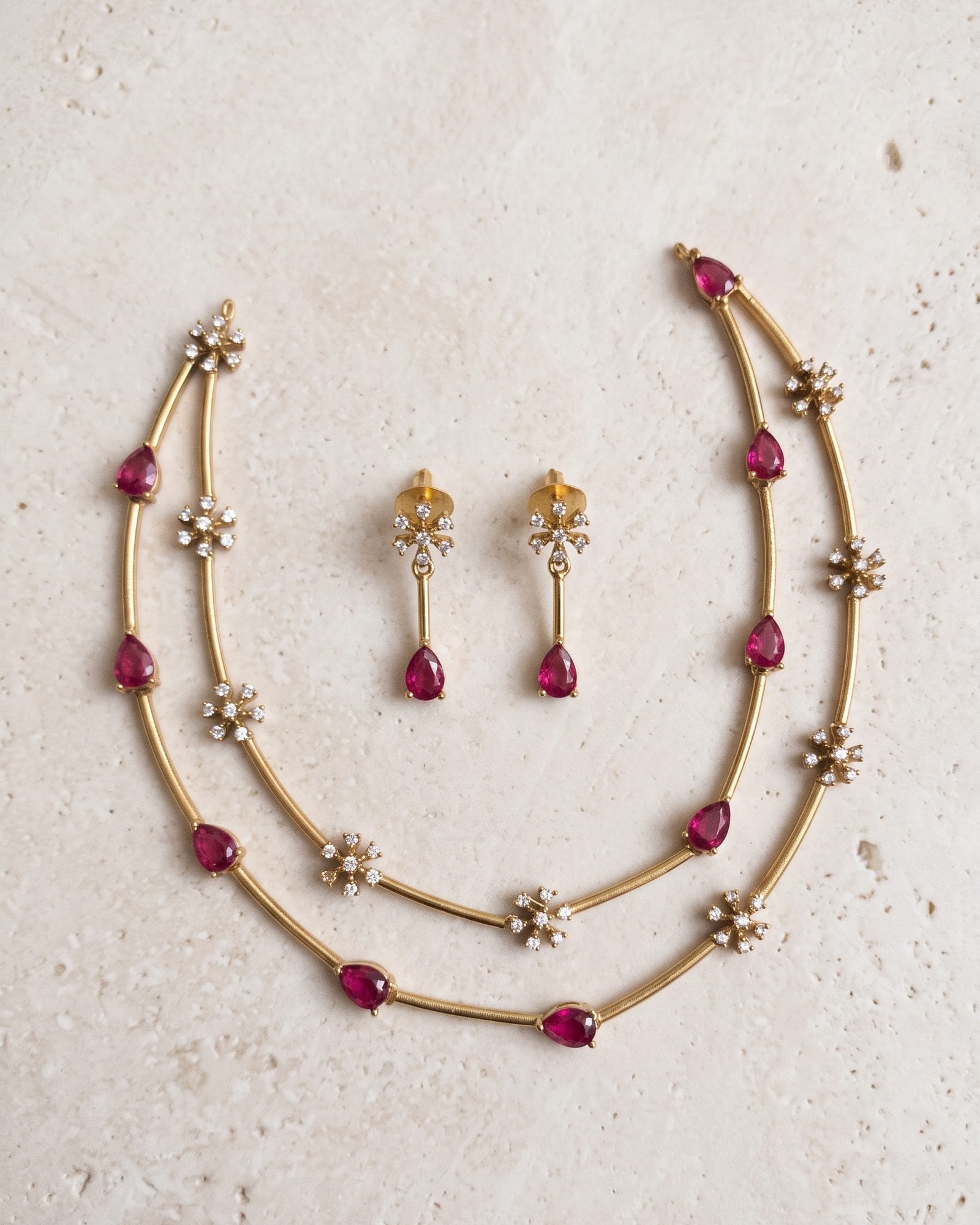 Ruby Glow Chain Set laid on white marble