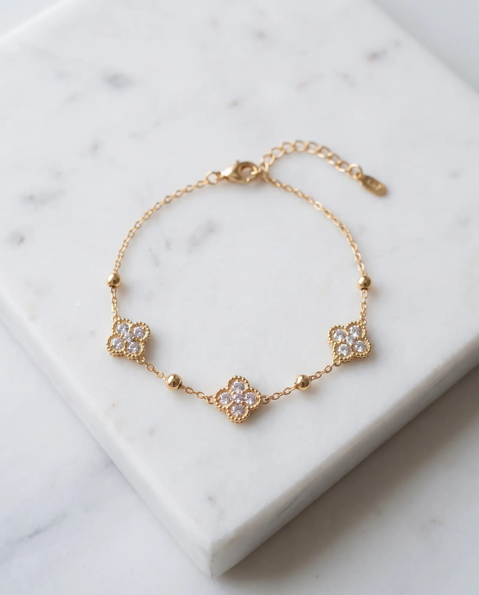 Triple Gem Flower Chain Bracelet Anti Tarnish laid on white marble